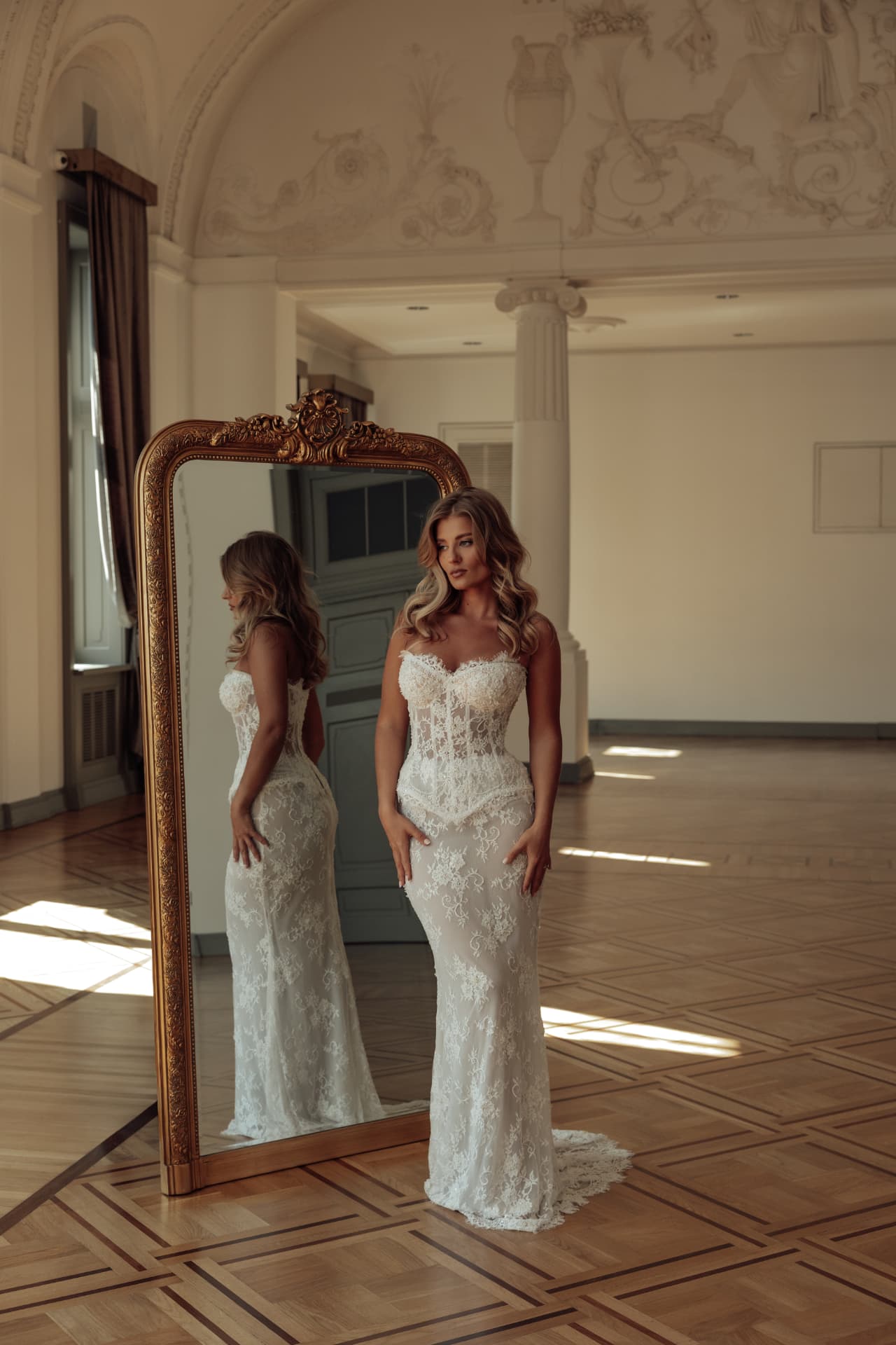 Silhouette of a lace wedding dress beside a mirror