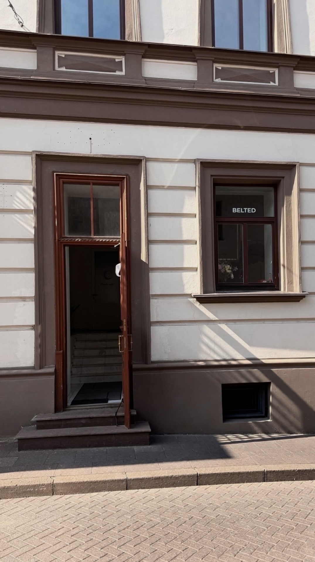 The entrance of the BELTED atelier — red doors at Vilniaus g. 28